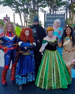 six people in costumes as captain marvel, merida, frozen, mona, and batman costumes